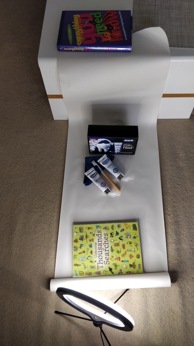 Product photography setup: Oral-B tubes kept on a white sheet and light source from a side