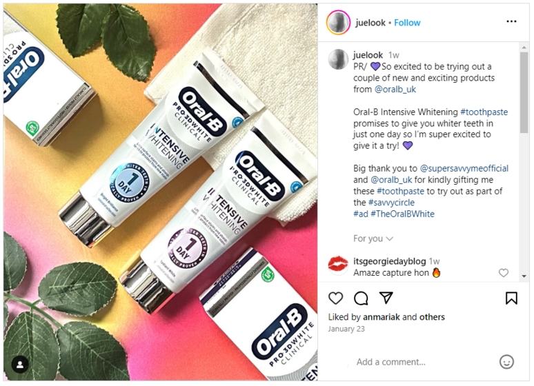 Tubes of Oral-B with a pink background and some leaves