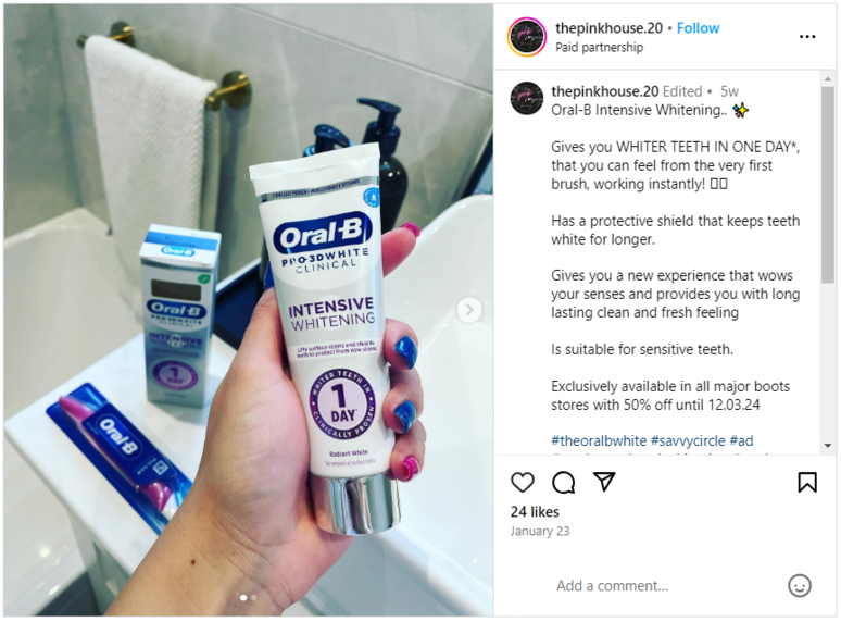 A hand holding an Oral-B tube