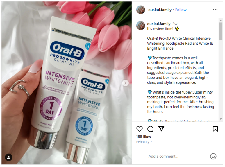 Picture of two Oral-B tubes and tulips in the background