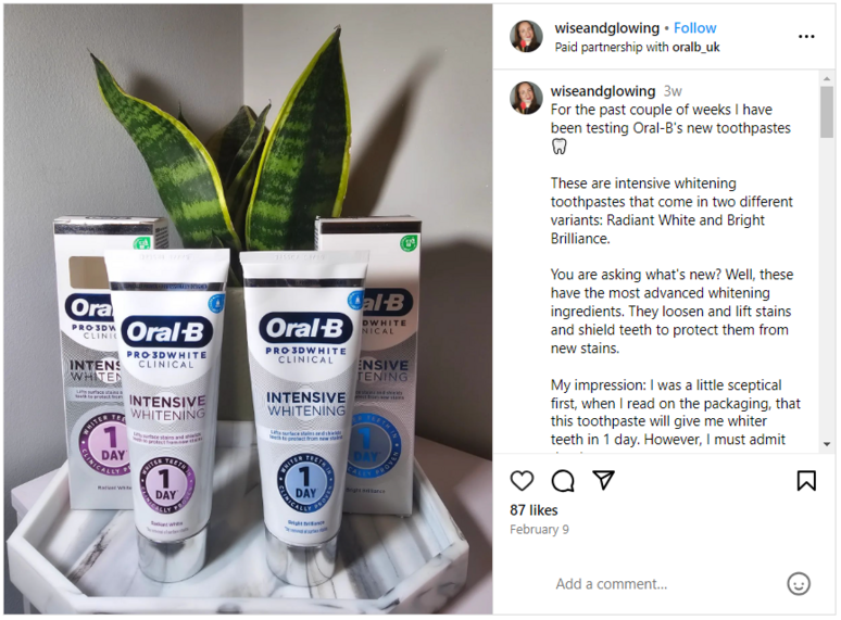 Oral-B tubes and box in front of a small house plant