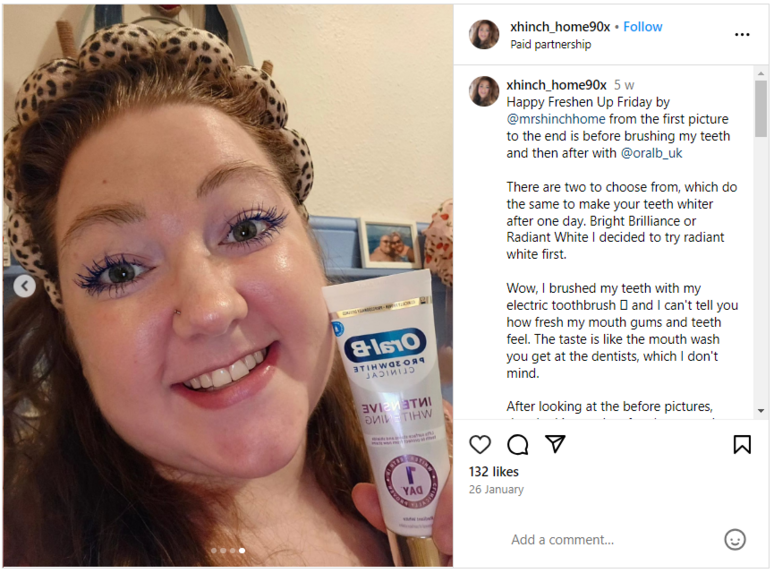 Woman holding an Oral-B tube while smiling